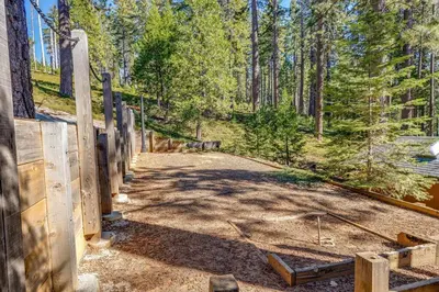 a dirt road in a forest with a wooden fence at WHouse*HotTub*Sleeps20*BLS*FirePit*AC&Heat*DogsOk in Arnold