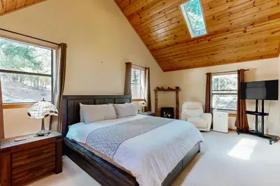 a bedroom with a bed and a tv and windows at Hot Tub Hideaway in Dorrington