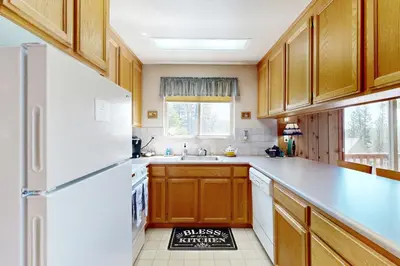 a kitchen with wooden cabinets and a white refrigerator at Cozy Chalet in Arnold