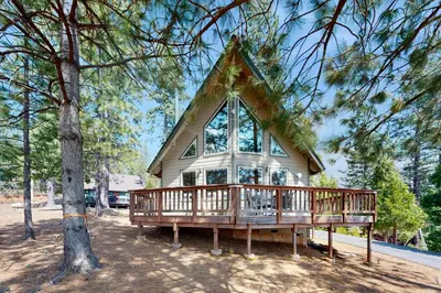 a small house with a large window on a deck at Cozy Chalet in Arnold