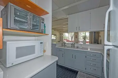 a kitchen with white cabinets and a microwave at Ala Wai BoulevardApartment 23 in Lake Valley