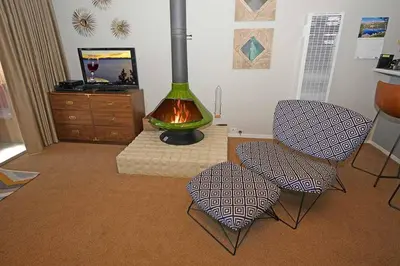 a living room with two chairs and a fireplace at Ala Wai BoulevardApartment 23 in Lake Valley