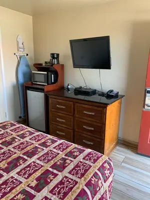 a bedroom with a bed and a television on a dresser at Jerry's Motel in Oakdale
