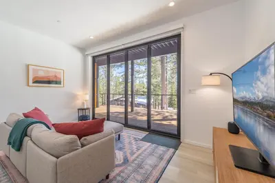 a living room with a couch and a large window at Modern Eco Retreat with Hot Tub and Views in Truckee