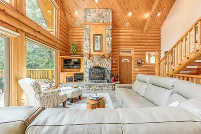 a living room with a couch and a fireplace at Mountain Cabin with Hot Tub 4 Mi to Shaver Lake! in Shaver Lake