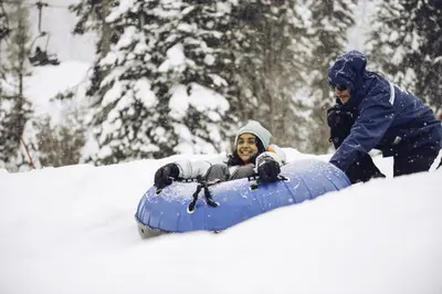 a man is riding on a snowboard in the snow at Lofted Retreat in The Village! condo in Truckee