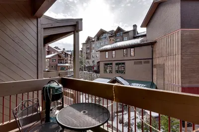 a balcony with a table and chairs and buildings at Lofted Retreat in The Village! condo in Truckee