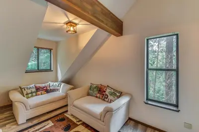 a living room with two chairs and a window at 2 Mi to Mi-Wuk Village Cabin with Large Deck in Twain Harte