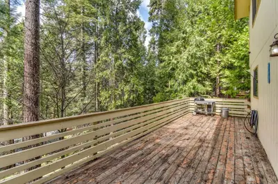 a wooden deck with benches on the side of a house at 2 Mi to Mi-Wuk Village Cabin with Large Deck in Twain Harte