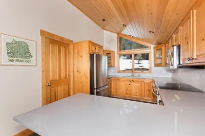 a kitchen with a stainless steel refrigerator and wooden cabinets at Mineral Springs 3 BR w Hot tub Available in Alpine Meadows in Olympic Valley