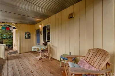 a porch of a house with a table and chairs at Suite Sunshine A in Yosemite West
