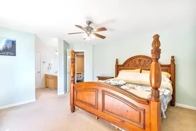 a bedroom with a wooden bed and a ceiling fan at Riverside Manna in Mariposa
