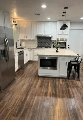 a kitchen with white cabinets and stainless steel appliances at Sequoia Villa in Visalia