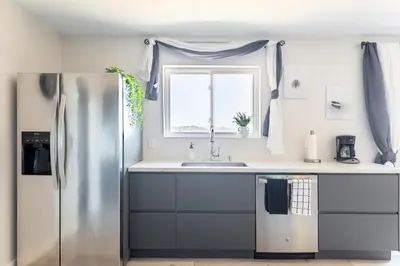 a kitchen with a stainless steel refrigerator and a window at Rolling Oaks Ranch - 200 Acres of Lakeside Beauty & Countryside Serenity in Mariposa