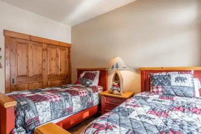 a bedroom with two beds and a table with a lamp at Cabins 24 in Mammoth Lakes