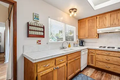 a kitchen with wooden cabinets and a sink at Kathy's Korner - Pet Friendy with Large Deck! home in Groveland