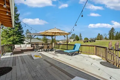 a wooden deck with an umbrella and chairs on it at Kathy's Korner - Pet Friendy with Large Deck! home in Groveland