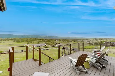 a wooden deck with two chairs and a playground at Hot Tub and Expansive Views Copperopolis Mtn Home in Copper Cove Subdivision