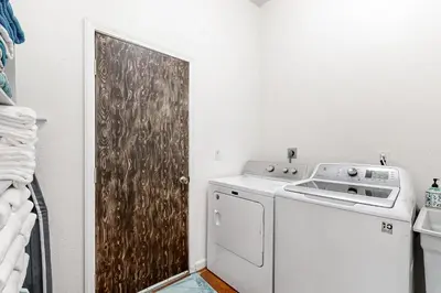 a laundry room with a washer and dryer next to a door at Hot Tub and Expansive Views Copperopolis Mtn Home in Copper Cove Subdivision