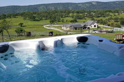 a hot tub with a view of a house at Hot Tub and Expansive Views Copperopolis Mtn Home in Copper Cove Subdivision