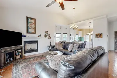 a living room with a leather couch and a tv at Hot Tub and Expansive Views Copperopolis Mtn Home in Copper Cove Subdivision