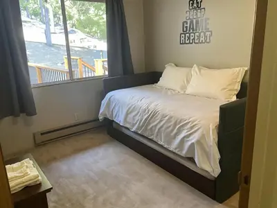 a small bed in a room with a window at The Cozy Cabin - 2-Level Home with Spacious Yard home in Groveland