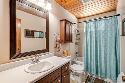 a bathroom with a sink and a toilet and a shower at The Cozy Cabin - 2-Level Home with Spacious Yard home in Groveland