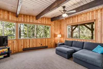 a living room with a couch and a tv at The Cozy Cabin - 2-Level Home with Spacious Yard home in Groveland