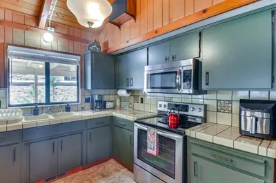 a kitchen with blue cabinets and stainless steel appliances at Cozy Cabin in Pine Mountain Lake Near Yosemite! in Groveland