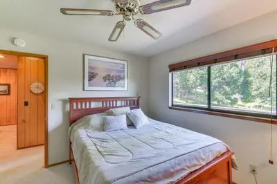 a bedroom with a bed and a ceiling fan at Cozy Cabin in Pine Mountain Lake Near Yosemite! in Groveland