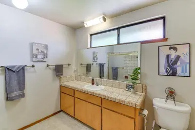 a bathroom with a sink and a toilet and a mirror at Cozy Cabin in Pine Mountain Lake Near Yosemite! in Groveland