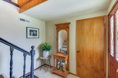 a hallway with a door and a table with a plant at Cozy Cabin in Pine Mountain Lake Near Yosemite! in Groveland