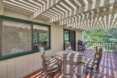 a screened in porch with a table and chairs at Cozy Cabin in Pine Mountain Lake Near Yosemite! in Groveland