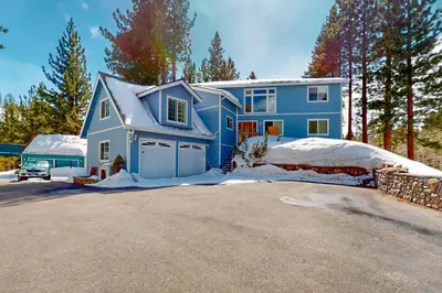 a blue house with a driveway in the snow at Andria Grove in Stateline