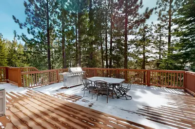 a wooden deck with a table and a grill on it at Andria Grove in Stateline