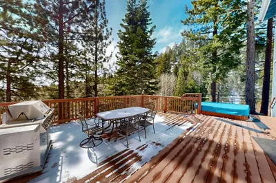 a deck with a table and chairs and a grill at Andria Grove in Stateline
