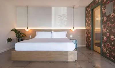 a bedroom with a large bed with white sheets at Best Bet Motor Lodge in Reno