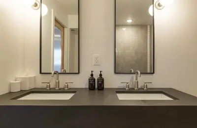 a bathroom with two sinks and two mirrors at Best Bet Motor Lodge in Reno