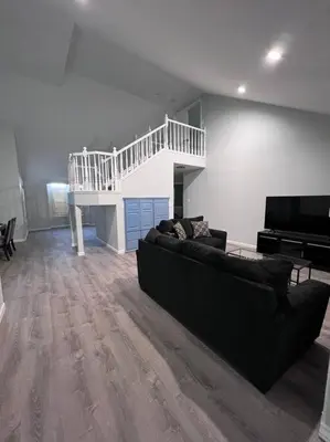 a living room with a black couch and a piano at Entire 3 BR & 2 BA house for business and family in Modesto