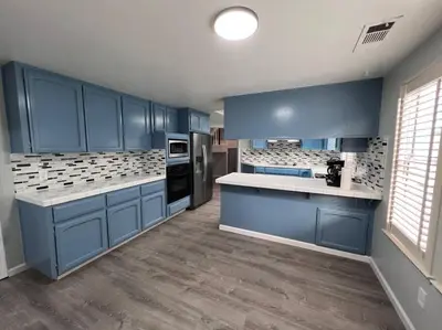 a kitchen with blue cabinets and white counter tops at Entire 3 BR & 2 BA house for business and family in Modesto