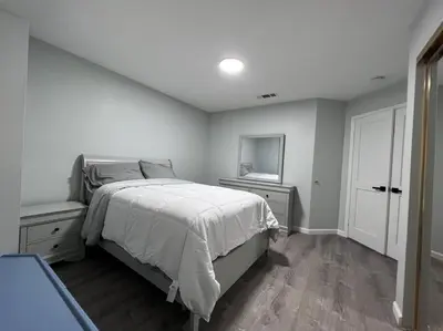 a white bedroom with a bed and a television at Entire 3 BR & 2 BA house for business and family in Modesto