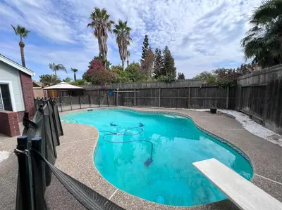 a swimming pool in a backyard with a fence at Entire 3 BR & 2 BA house for business and family in Modesto