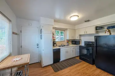 a kitchen with a black refrigerator and a table at Mountain View, near Yosemite & Bass Lake, BBQ, Fireplace,EVC in Oakhurst