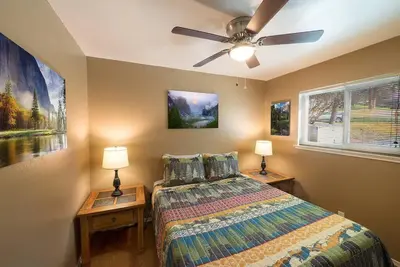 a bedroom with a bed and two night tables with lamps at Mountain View, near Yosemite & Bass Lake, BBQ, Fireplace,EVC in Oakhurst