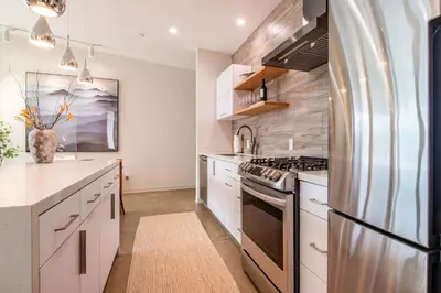 a kitchen with white cabinets and a stainless steel refrigerator at Horizon by Yosemite in Midpines