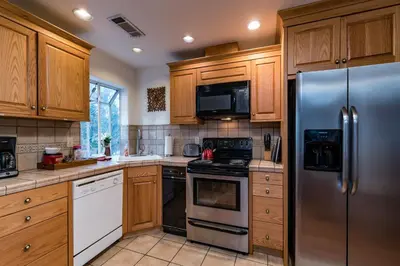 a kitchen with wooden cabinets and a stainless steel refrigerator at Spring Wonderland in Yosemite West