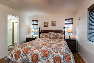 a bedroom with a large bed and two windows at Spring Wonderland in Yosemite West