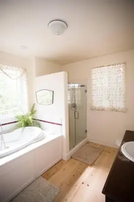 a white bathroom with a tub and a shower at Yosemite Firehouse Inn in Mariposa