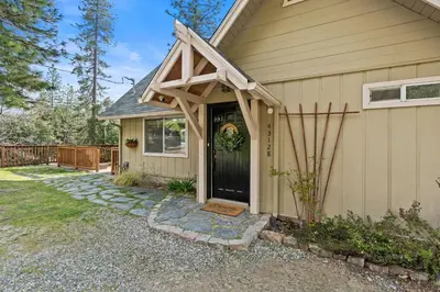 a house with a wooden awning over the door at Cozy Yosemite Family Retreat-13mi to South Gate in Oakhurst