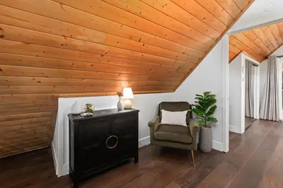 a living room with a wooden ceiling and a chair at Cozy Yosemite Family Retreat-13mi to South Gate in Oakhurst